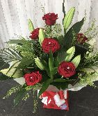 red roses and lilys in a front facing display